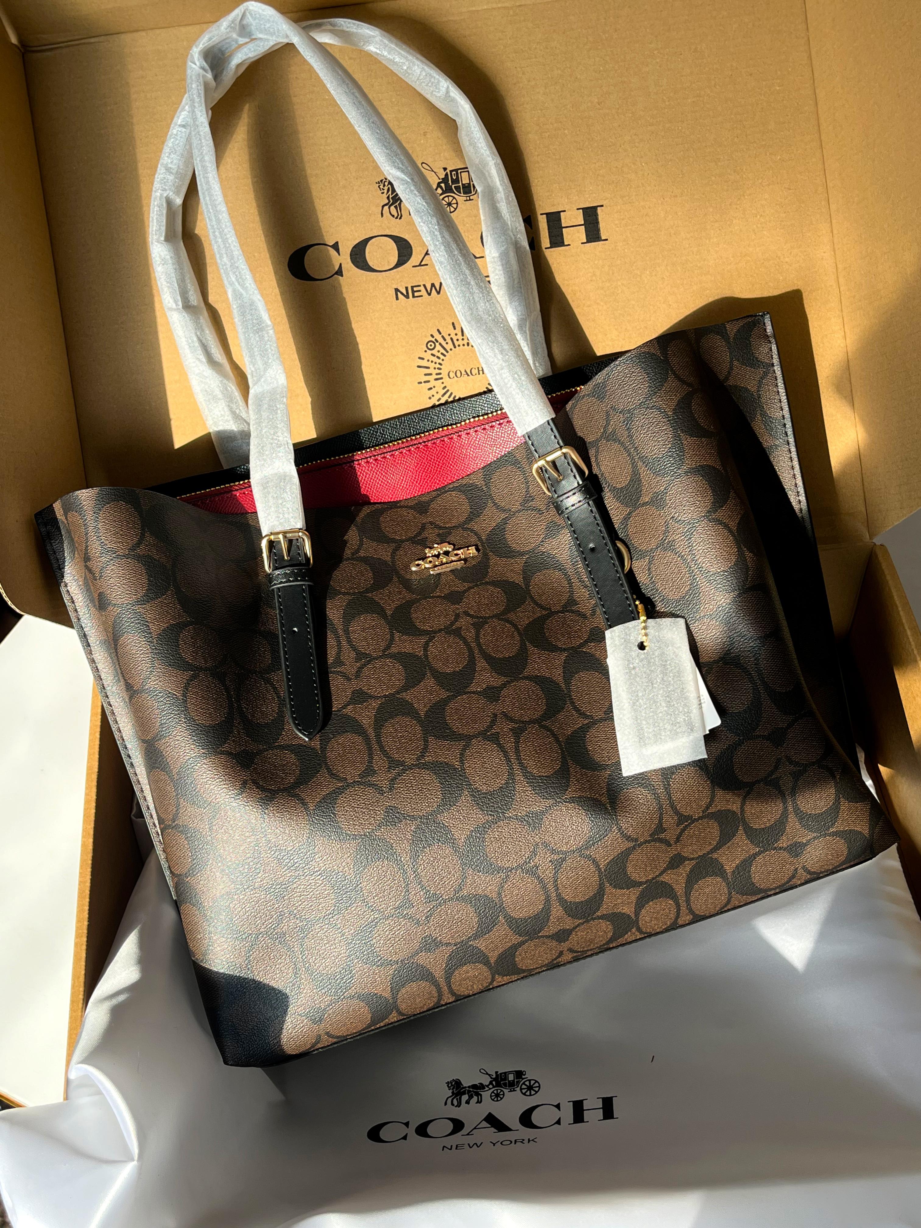 Coach handbag with a visible tag on a white surface with Coach branding.