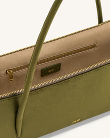 Green handbag with beige interior and gold zipper on a white background